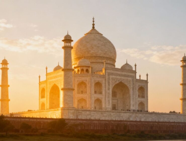 Taj Mahal glowing softly in silver-white marble under a clear full moon and starry night sky, viewed from a distance with peaceful surroundings.