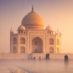Soft winter light reflecting the Taj Mahal in calm morning water