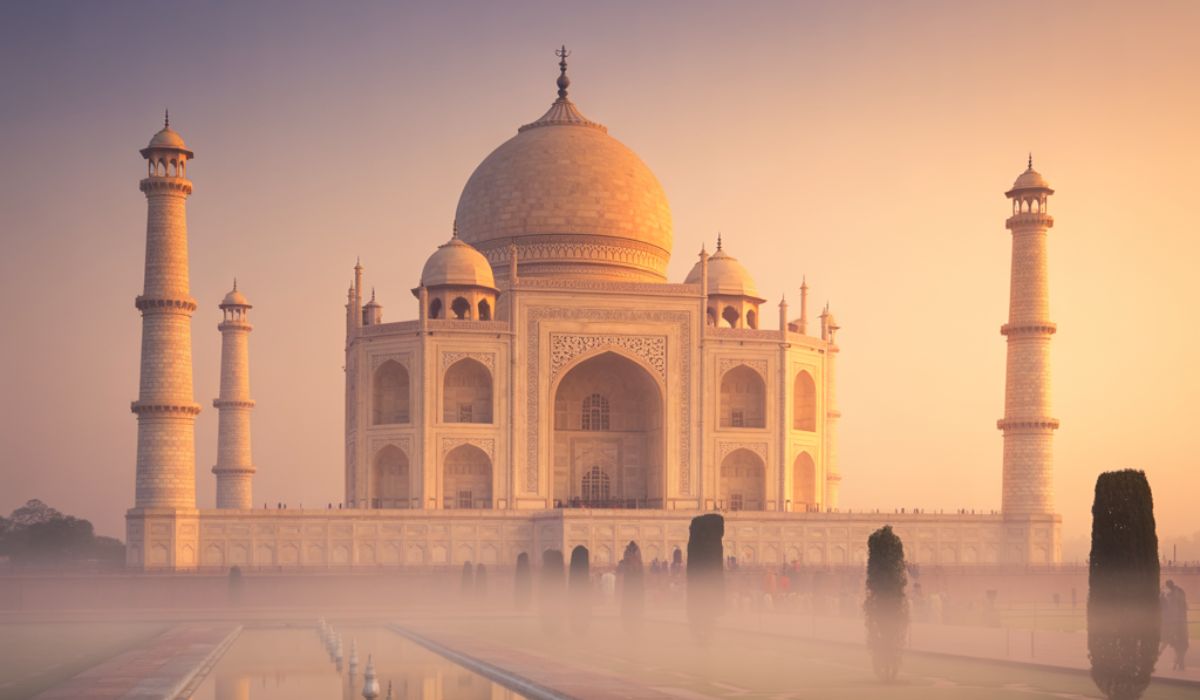 Soft winter light reflecting the Taj Mahal in calm morning water
