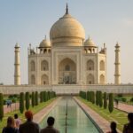 Tourists walking along the Taj Mahal’s reflecting pool toward the monument on a clear day.