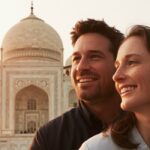 Smiling couple enjoying a Delhi to Taj Mahal trip with the Taj Mahal in the background during sunrise.
