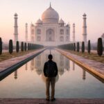 A solitary visitor standing quietly before the Taj Mahal at dawn.