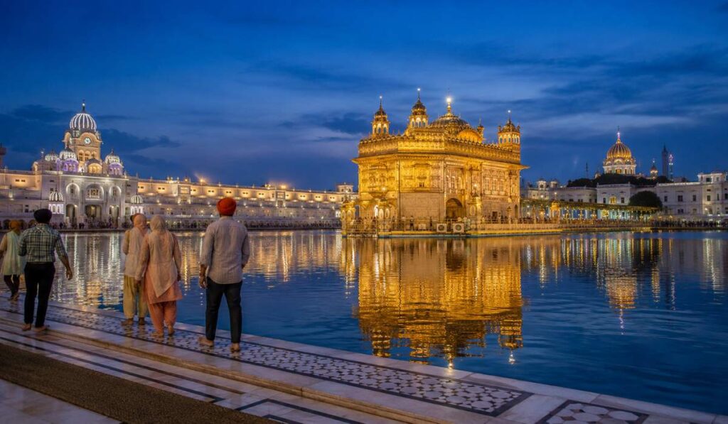 Golden Temple Harmandir Sahib illuminated in the evening with reflection in the sacred sarovar